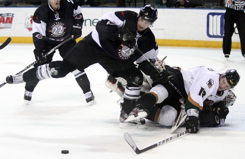 Rick Egan  | The Salt Lake Tribune 

The Grizzlies' Jeff LoVecchino (18) lands on Wrangler goal keeper Mitch Okeele (1) as he tries to get the puck along with Wrangler, Channing Boe (25) for the puck, in ECHL action Grizzlies vs. The Las Vegas Wrangles, at the Maverick Center,  Monday, April 2, 2012.