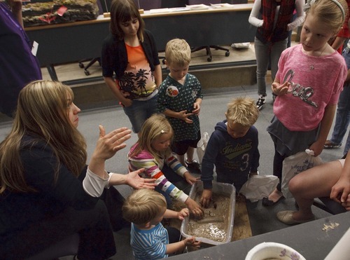 Leah Hogsten  |  The Salt Lake Tribune
Weber State University senior student Sara Yearsley talks on Saturday about what happens during an earthquake as children poke their fingers into sand slurry to show how the earth liquifies during earthquake preparedness event.