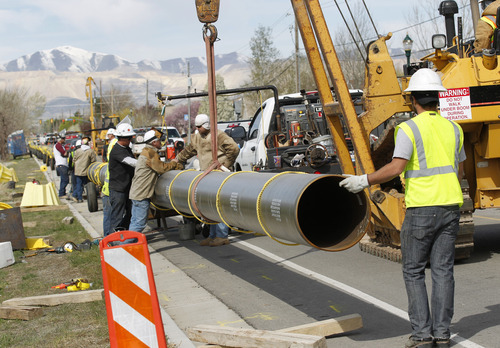 Al Hartmann  |  The Salt Lake Tribune 
Workers lay down pipe along 134000 South and 2400 West. Questar is replacing 8.5 miles of feeder line that runs along 13400 South in Riverton and Herriman. The project is expected to be completed later this summer.