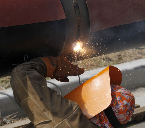 Al Hartmann  |  The Salt Lake Tribune 
Worker welds pipes together along 134000 and 2400 West on Tuesday April 10. Questar is replacing 8.5 miles of feeder line that runs along 13400 South in Riverton and Herriman. The project is expected to be completed later this summer.