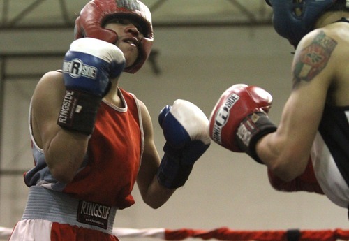 Rick Egan  | The Salt Lake Tribune 

Jr. Torez, Salt Lake, (red) fights Roberto Perez, Gate City, (white) in the113 lb division, in the Rocky Mountain Golden Gloves Regionals at the Sports Mall in Murray, Saturday, April 14, 2012.