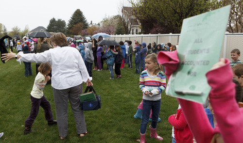 Trent Nelson  |  The Salt Lake Tribune
First graders at Granite Elementary stand in the rain after evacuating the school during a statewide earthquake drill Tuesday, April 17, 2012 in Sandy, Utah.