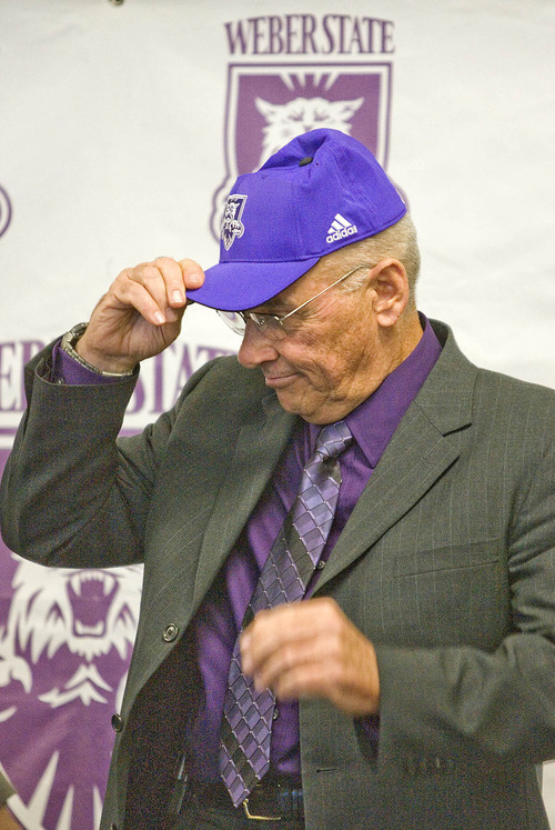 Paul Fraughton | The Salt Lake Tribune
John L. Smith dons a purple Weber State cap at  the press conference where he was introduced   as Weber State's new head football coach.
  Tuesday, December 6, 2011