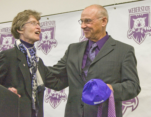 Paul Fraughton | The Salt Lake Tribune
Weber State University President, Ann Milner  provides John L. Smith with a few purple Weber State ties and a hat as he is introduced at a press conference as Weber State's new head football coach.
  Tuesday, December 6, 2011