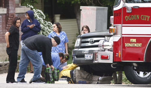 Leah Hogsten  |  The Salt Lake Tribune
Bystanders and Ogden City Firefighter tend to a man lying under a vehicle after an automobile/ pedestrian accident Friday, April 27 2012 at the intersection of Harrison Blvd. and 24th Street in Ogden that occurred at 12:35p.m.