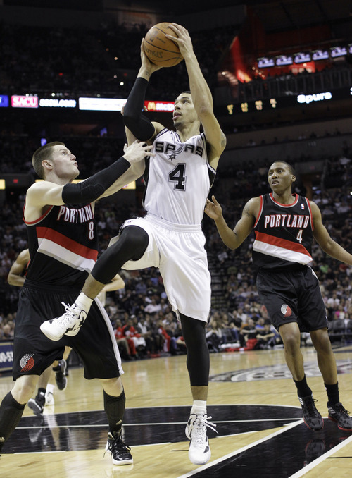 San Antonio Spurs' Danny Green (4) goes up between Portland Trail Blazers' Luke Babbitt (8) and Nolan Smith (4) during the first quarter of an NBA basketball game, Monday, April 23, 2012, in San Antonio. San Antonio won 124-89. (AP Photo/Eric Gay)