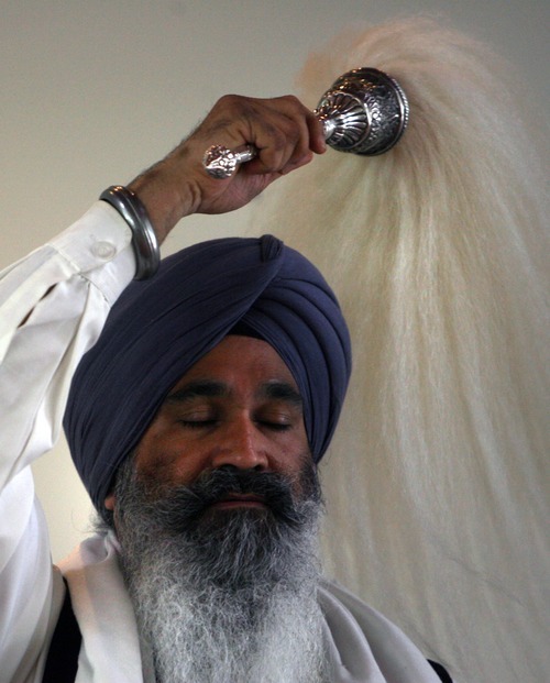 Kim Raff | The Salt Lake Tribune
Bhai Sahib Gurmeet Singh protects the Guru Granth Sahib, Sikh religious text, during a Sikhs of Utah worship service at the Sikh Temple in Taylorsville on April 22, 2012.
