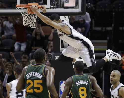 San Antonio Spurs' Danny Green hangs on the rim after he scored against the Utah Jazz during the first quarter of Game 2 of a first-round NBA basketball playoff series, Wednesday, May 2, 2012, in San Antonio. (AP Photo/Eric Gay)