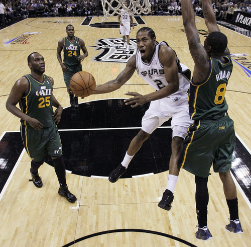 San Antonio Spurs' Kawhi Leonard (2) drives to the basket as Utah Jazz's Josh Howard (8) and Al Jefferson (25) defend during the first quarter of Game 2 of a first-round NBA basketball playoff series, Wednesday, May 2, 2012, in San Antonio. (AP Photo/Eric Gay)