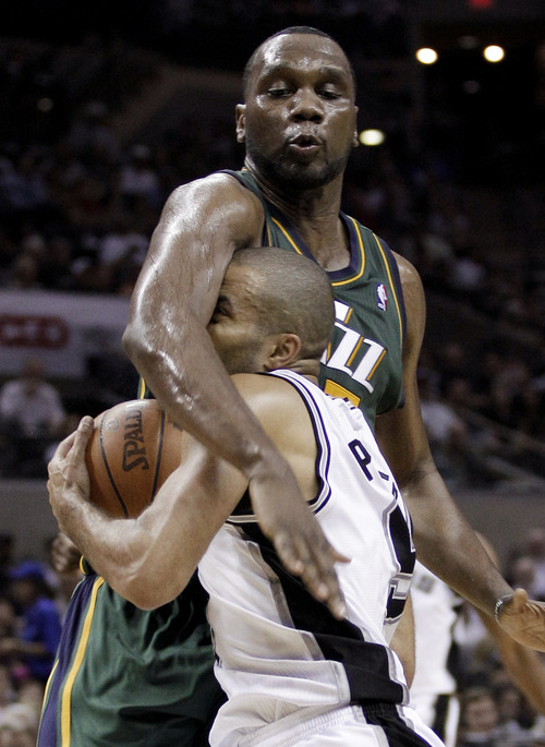 San Antonio Spurs' Tony Parker, front, is fouled by Utah Jazz's Al Jefferson during the third quarter of Game 2 of a first-round NBA basketball playoff series, Wednesday, May 2, 2012, in San Antonio. (AP Photo/Eric Gay)