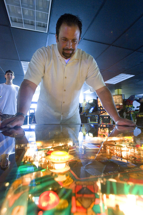 Paul Fraughton  |  The Salt Lake Tribune
As Atomic Arcade owner Chris Wright looks on, Larry Schmidt, an avid game player, tries out a vintage pinball machine at the Holladay business.