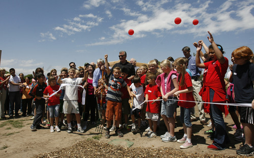 Rick Egan  | The Salt Lake Tribune 

Mayor Peter Carroon with the help of tudents from Driggs Elementary School, cut the ribbon during the grand opening of the community garden in Holladay,  Friday, May 4, 2012.  The Mount Olympus Garden is a cooperative venture for Howard R. Driggs Elementary School, Olympus Junior High School, Salt Lake City, Holladay City, Salt Lake County, and New Roots of Utah in partnership with the International Rescue Committee.