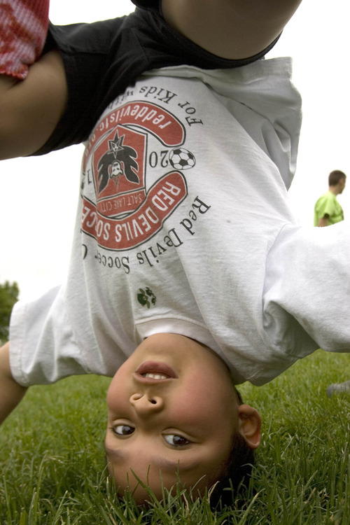 Paul Fraughton | The Salt Lake Tribune
Charlie Cunningham takes a break from soccer to do some impromptu headstands and cartwheels. Charlie joined other kids with autism at a soccer clinic run by the RedDevils Soccer Club at the Carmen B. Pingree School and Sunnyside Park in Salt Lake City. 
 Thursday, May 3, 2012