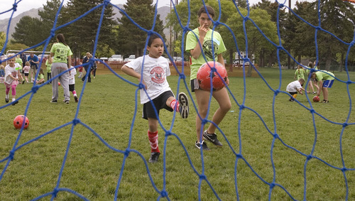 Paul Fraughton | The Salt Lake Tribune 
Parker Winchester, a volunteer mentor watches as Charlie Cunningham kicks the ball into the net. Charlie joined other kids with autism at a soccer clinic run by the RedDevils Soccer Club at the Carmen B. Pingree School and Sunnyside Park in Salt Lake City. 
 Thursday, May 3, 2012