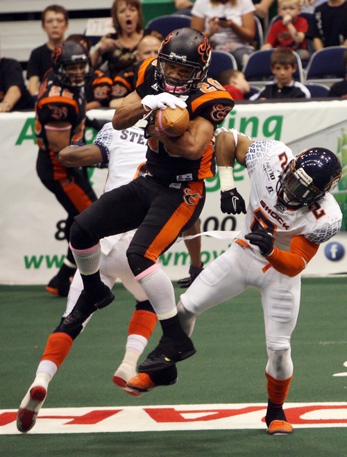 Kim Raff | The Salt Lake Tribune
Utah Blaze player Chris Bocage catches a pass over the heads of Spokane Shock players (left) Paul Stephens and Josh Ferguson during a game at the EnergySolutions Arena in Salt Lake City, Utah on May 4, 2012.
