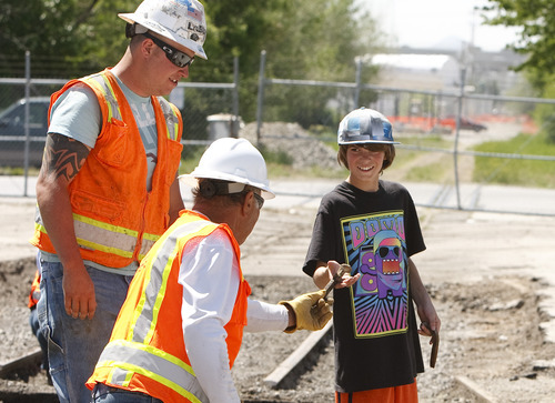 Leah Hogsten  |  The Salt Lake Tribune
Graham Colgan,12, is handed old railroad spikes from the Denver and Rio Grande line from Stacy & Witbeck laborers during the groundbreaking on the Sugar House streetcar project  Wednesday, May 9 2012 in Salt Lake City. The two-mile route will run from the 2100 South TRAX Station to the Sugar House commercial district near Highland Drive and 2235 South.