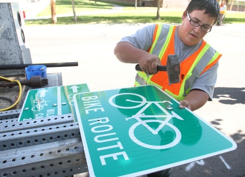 Rick Egan  | The Salt Lake Tribune 
Salt Lake County sign specialist Orrey Nell prepares a bike route sign for Mayor Peter Corroon to install Monday on Evergreen Avenue in East Millcreek. The installation of bike route signs is part of Salt Lake County's new County Connectivity Project, which links major routes and popular destinations.