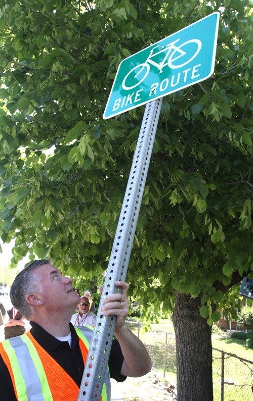Rick Egan  |  The Salt Lake Tribune 
Salt Lake County Mayor Peter Corroon prepares to install a bike route sign on Evergreen Avenue on Monday to raise awareness about Salt Lake County's new connectivity project.