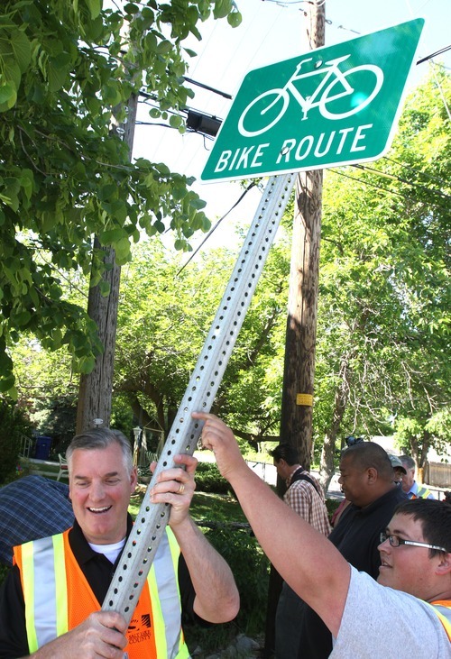 Rick Egan  | The Salt Lake Tribune 
Salt Lake County Mayor Peter Corroon prepares to install a bike route sign with the help of sign specialist Orrey Nell on Evergreen Avenue.