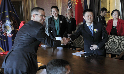 Al Hartmann  |  The Salt Lake Tribune
Spencer P. Eccles Jr., executive director of the Governor's Office of Economic Development, left, reaches across table at the state Capitol to shake hands with Deng Yuyang, a representative of Chinese sculpture artist Yuan Xikun in thanks for  a three-generation statue of Chinese railroad workers. About 2,600 Chinese laborers worked on the transcontinental railroad completed 143 years ago at Promontory  Summit, near Brigahm City.