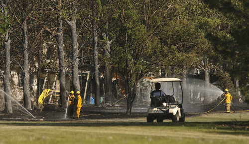 Leah Hogsten  |  The Salt Lake Tribune
South Jordan firefighters battle a  brush fire that started near Glenmoor Golf Course on Tuesday, May 15, 2012, in South Jordan. The fire, which heavily damaged one home and led to the evacuation of nearly two dozen others, remained under investigation Wednesday.