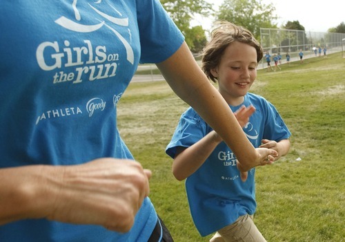 Leah Hogsten  |  The Salt Lake Tribune
Mentor Emeliee Dirks (left) congratulates student Lizzy Blackwell for her efforts while running around Morningside Elementary's playground.  Morningside Elementary 3rd -6th grade girls run into shape after school for a 5k run with the guidance of  trained coaches that mentor the girls Wednesday, May 16 2012 in Salt Lake City..  Girls on the Run is a national non-profit in 43 states. The 12-week program concludes with all participants walking or running in a 5K (3.1 mile) event.