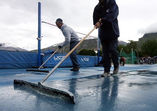 Kim Raff | The Salt Lake Tribune
(left) Jon Quist and Doug Pdilla try and squeegee rain water off of the high jump event during theUHSAA State Track Competition at the Clarence F. Robison Track & Field Stadium in Provo, Utah on May 18, 2012.