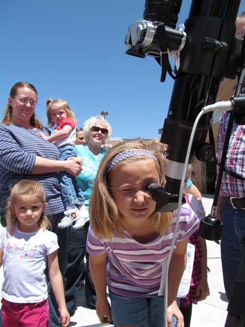 Sheena McFarland | The Salt Lake Tribune
Amanda Pratt, 9, looks into a solar telescope at the Solar Eclipse Extravaganza at the Aquatic Center at the Hills in Cedar City on Saturday. Her mother, Sara Pratt, holds another daughter, Rebecca, 21 months, as Hailey Pratt, 4, looks on. The family visited Cedar City from Springville, three hours to the north, for the eclipse.