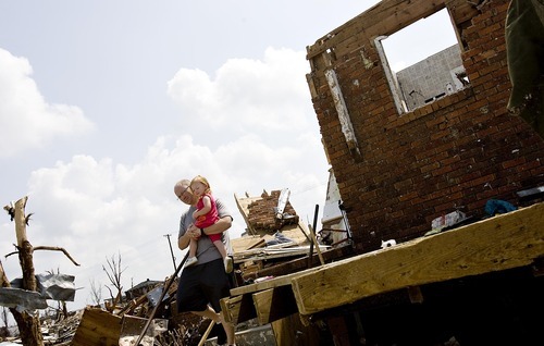 Djamila Grossman  |  The Salt Lake Tribune

Adam Wright holds his daughter, Grace, 2, as he stands on the steps of the home of his parents in-law where they hid during the recent tornado in Joplin, Missouri, on Wednesday, June 1, 2011.