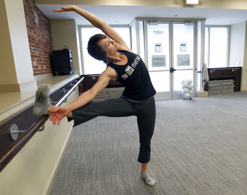 Al Hartmann  |  The Salt Lake Tribune
Carrie Goodwin, owner and instructor at The Bar Method in Salt Lake City, does a stretch at the bar as one of the moves in her excercise class. The workout 