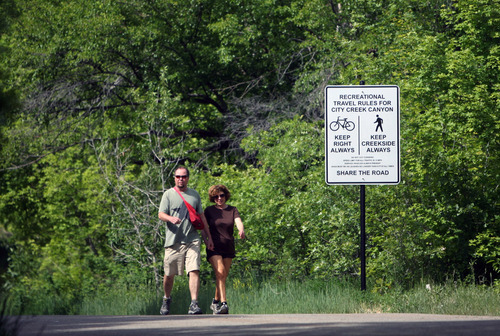 Kim Raff | The Salt Lake Tribune
(left) David Mackay and Sohayla Jewett  walk past one of the new signs installed on the City Creek Trail for bikers and pedestrians in Salt Lake City, Utah on May 25, 2012.