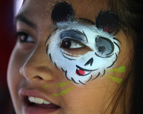 Rick Egan  | The Salt Lake Tribune 

Anaseini Tuutau, 9, checks out her face in the mirror, after having her face painted at the Valley View cemetery in West Valley, Monday, May 28, 2012. Valley VIew Cemetery offers free hot dogs and sodas to people visiting their family's graves, as well as face painting.