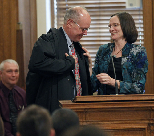 Al Hartmann  |  The Salt Lake Tribune 
David Nuffer is helped into his new judicial robe by wife Lori after being sworn in as a U.S. District Court judge at the Frank Moss Federal Courthouse in Salt Lake City on Tuesday, May 29.