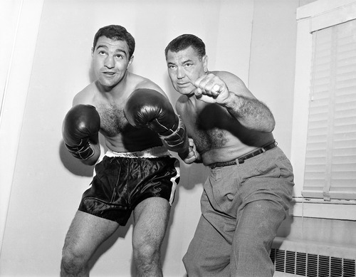 Ex-heavyweight champion Jack Dempsey, right, strikes a familiar pose with heavyweight Rocky Marciano during visit to Rocky's training camp at Grossinger in New York on Sept. 9, 1952. Rocky is training at the upstate spot for his Sept. 23, title bout with champion Jersey Joe Walcott in Philadelphia, Pa. Jack said the bout 