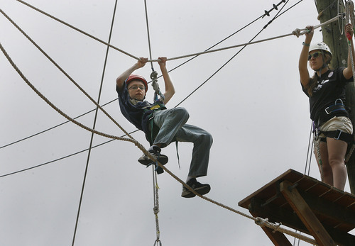 Scott Sommerdorf  |  The Salt Lake Tribune             
While on belay, 12-year-old Jordan Duckworth, of Syracuse, navigates a ropes course Saturday while at Family Fun Day at Camp Kostopulos. The camp provides outdoor recreational experiences to families with children with special needs. There was swimming, horseback riding, jump houses, a ropes course, fun and food at Camp Kostopulos in Emigration Canyon, Saturday, June 2, 2012.