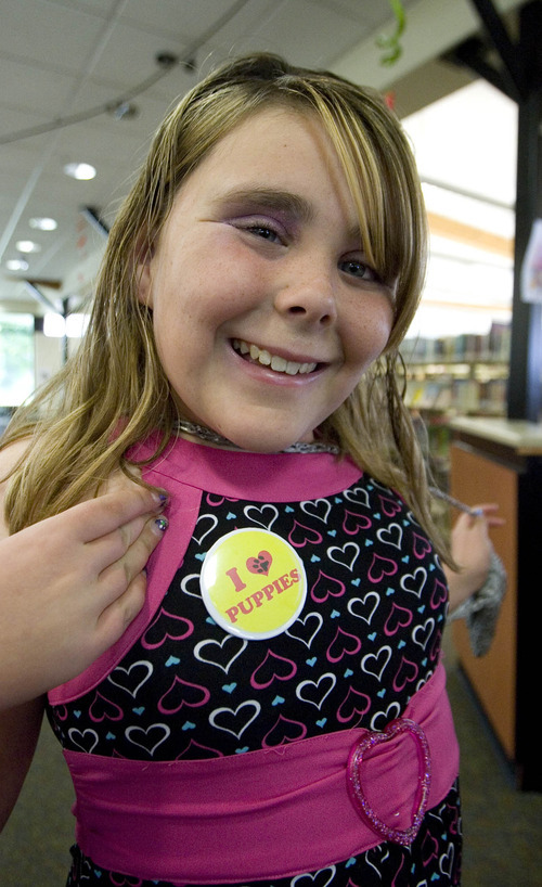 Paul Fraughton  |  Salt Lake Tribune
Samantha Gallegos, 12, shows off the button she made at the library. The activity is one the West Valley Library will feature in its summer reading program.