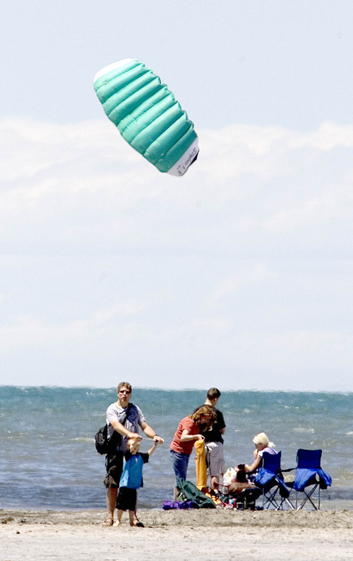 Paul Fraughton | Salt Lake Tribune
Taking advantage of a gentle breeze blowing on  the beach at Saltair, Carl Howard, from Hyrum, helps his nephew Landon Howard, 5, fly a parafoil kite Friday June 8, 2012 in Salt Lake City.