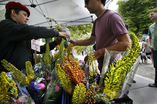 Scott Sommerdorf  |  The Salt Lake Tribune             
A customer is served at the Happy Trowels flower booth from Ogden at the opening Saturday of the Salt Lake Farmers Market, Saturday, June 9, 2012.