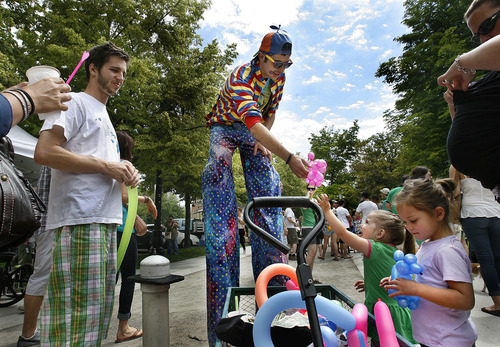 Scott Sommerdorf  |  The Salt Lake Tribune             
Two young girls get balloon animals from a balloon artist on stilts at the opening Saturday of the Salt Lake Farmers Market, Saturday, June 9, 2012.