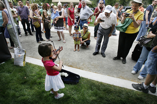 Scott Sommerdorf  |  The Salt Lake Tribune             
Three-year-old Samantha Ricks playing a tiny violin captivates the passersby at the opening Saturday of the Salt Lake Farmers Market, Saturday, June 9, 2012.