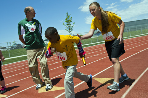 Chris Detrick  |  The Salt Lake Tribune
Kahvon Ford, 9, and Chandrelyn Kraczek, 15, of the Davis Angels team, compete in the 4x100 meter relay race during the 43rd Special Olympics summer games at Herriman High School Saturday June 9, 2012.