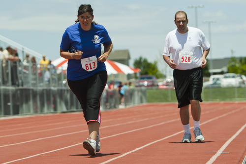 Chris Detrick  |  The Salt Lake Tribune
Margaret GrandBois, of team Turn Lightning, and Brian Allred, of team Weber State Wildcats, compete in the 800 meter run during the 43rd Special Olympics summer games at Herriman High School Saturday June 9, 2012.