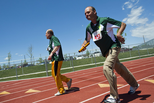 Chris Detrick  |  The Salt Lake Tribune
Kevin Peterson and Robert Gunn, of the Davis Angels team, compete in the 4x100 meter relay race during the 43rd Special Olympics summer games at Herriman High School Saturday June 9, 2012.