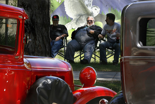 Scott Sommerdorf  |  The Salt Lake Tribune             
Friends Dave Bernini, left, Larry Neilsen, and his son Ross, right, lounge near the Tracy Aviary on the south side of Liberty Park as they show their classic cars, Sunday, June 10, 2012. Larry Neilsen's red customized 1934 Ford pickup is at left.