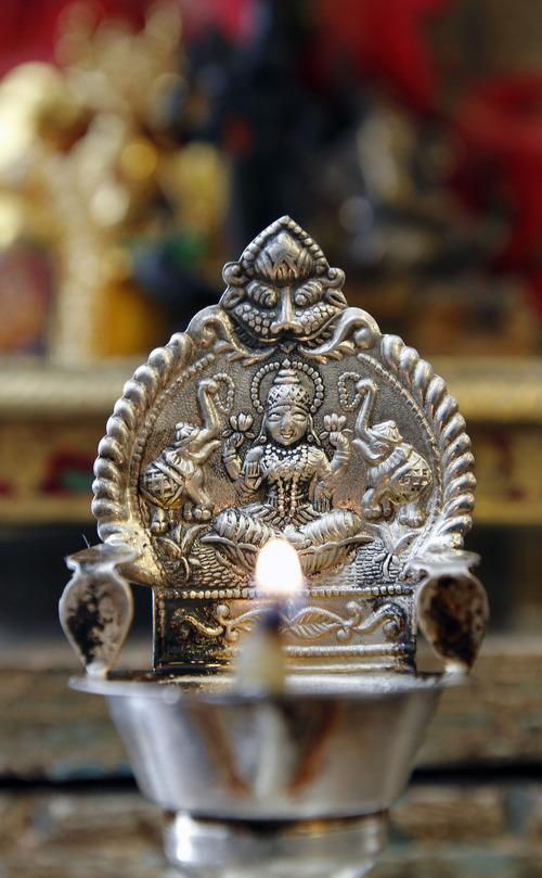 Al Hartmann  |  The Salt Lake Tribune 
A lighted candle in the east-facing shrine is part of  a daily ritual in a Hindu home.
