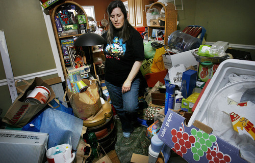 Scott Sommerdorf  |  The Salt Lake Tribune             
K Kay walks down the path through her living room. A path through a packed room is typical of hoarding behavior. K Kay is a hoarder who is trying to become an advocate for other hoarders. She's done a presentation for Sandy City code enforcement about the mental health issues behind hoarding, and she's trying to set up a support network for local hoarders, Thursday, May 24, 2012.