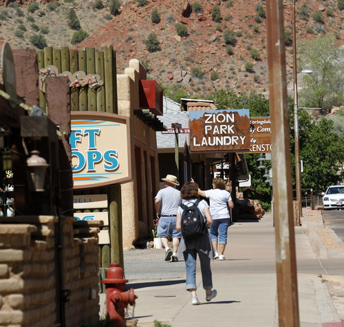 Al Hartmann  |  The Salt Lake Tribune 
Tourists walk past shops along Zion Park Blvd, on Springdale Monday June 11.  A Utah state audit says that Springdale police were illegally collecting money from foreign tourists and some of the cash is missing.