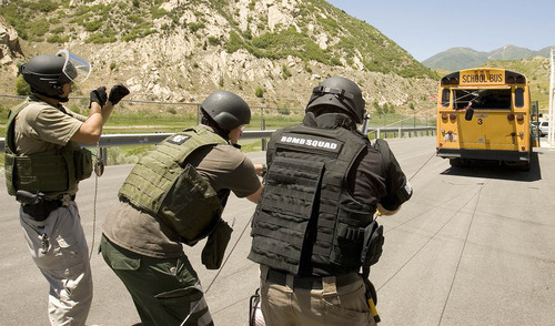 Paul Fraughton | The Salt Lake Tribune
Jeff Tracy and Sam Sorensen of Provo Utah County Metro Bomb Squad and Ren Egbert of Salt Lake County Unified Fire Department,  use ropes and pulleys to carefully remove a mock explosive device  from  a school bus, which  was used to simulate a passenger  airplane. This was one of eight scenarios faced by members of area bomb squads at a training exercise/competition held at  the Utah County Sheriff's Firearms Range near Thistle on Wednesday, June 13, 2012.