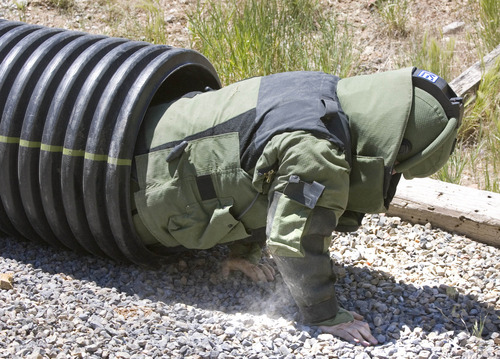 Paul Fraughton | The Salt Lake Tribune
 Brandon Miles of the  Weber County Sheriff's Office, wearing an 85-pound bomb suit,  crawls through a  pipe as part of an obstacle course. This was one of eight scenarios faced by members of area bomb squads at a training exercise/competition held at  the Utah County Sheriff's Firearms Range near Thistle on Wednesday, June 13, 2012.