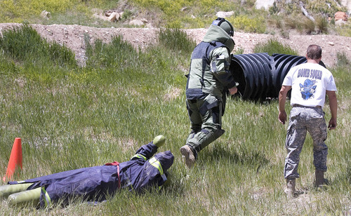 Paul Fraughton | The Salt Lake Tribune
 Brandon Miles of the  Weber County Sheriff's Office, wearing an an 85-pound bomb suit,  drags a weighted dummy through an obstacle course. The exercise was part of a training competition held at  the Utah County Sheriff's Firearms Range near Thistle on Wednesday, June 13, 2012.